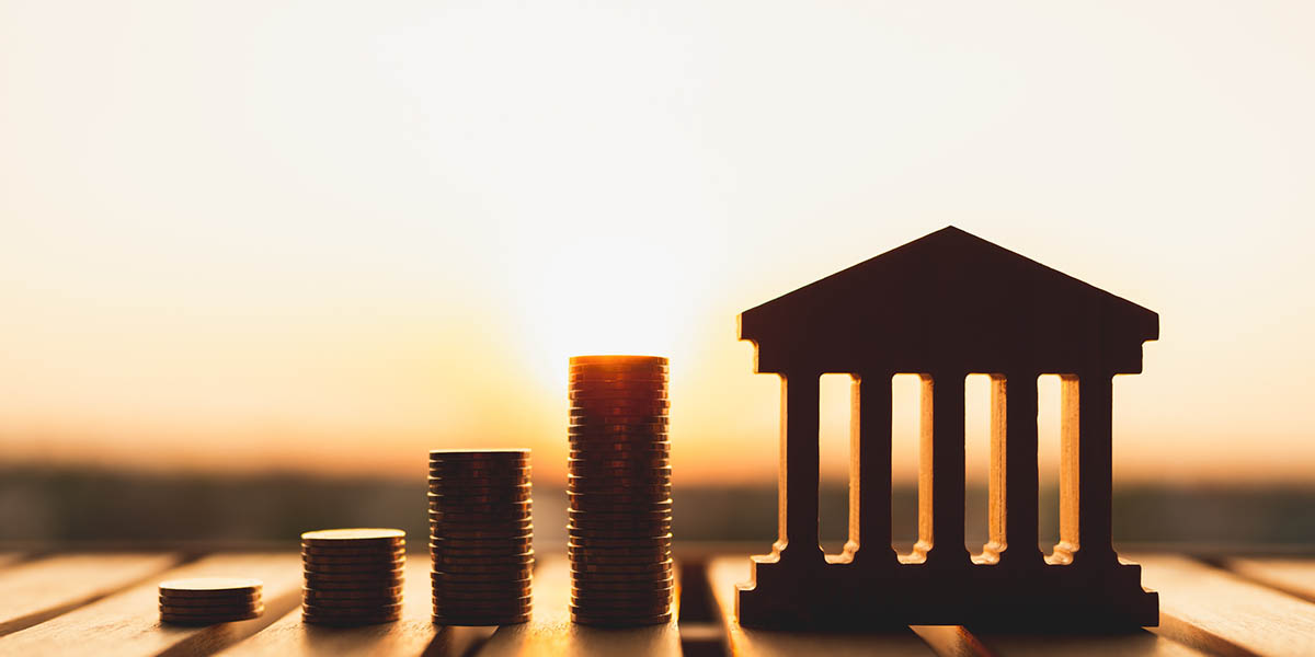 Bank symbol with with coins stack. Concepts of the banking system, rising interest rates, inflation, deflation, and savings.