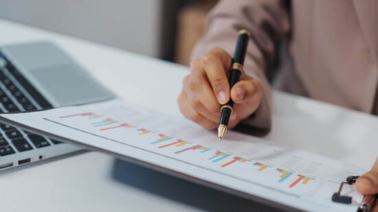 An Asian businesswoman accountant calculates invoices, taxes, interest, loans using a calculator,working online to guide clients through financial planning ensure a smooth loan process for success