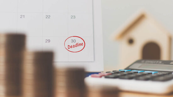 Tax payment season and finance debt collection deadline concept. Money coins stack, calendar, calculator and wooden house