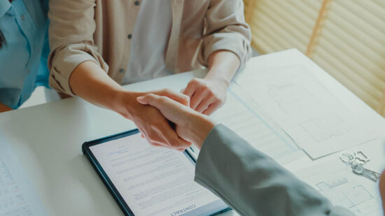 Close-up of Asian tenants sign house agreements on tablet and give them to female real estate agent after showing new houses. Landlord selling real estate to customers for investment.