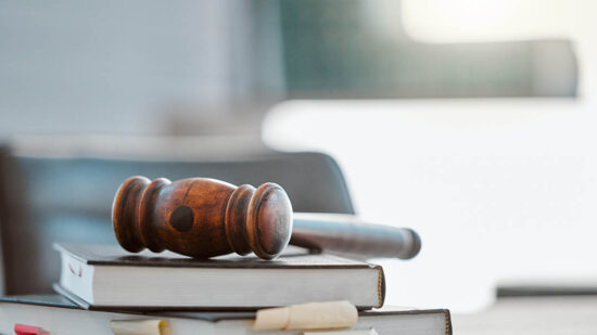 Justice, gavel and law books on table in office for court trial, legislation or fair constitution by judicial system. Firm, closeup and legal hammer by information for corporate case in workplace.