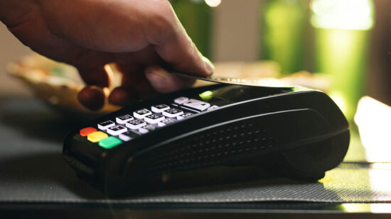 Credit card machine for money transaction. Close up of male hold in hand wireless modern bank payment terminal to process acquire credit card payments black card. Credit card through pos terminal
