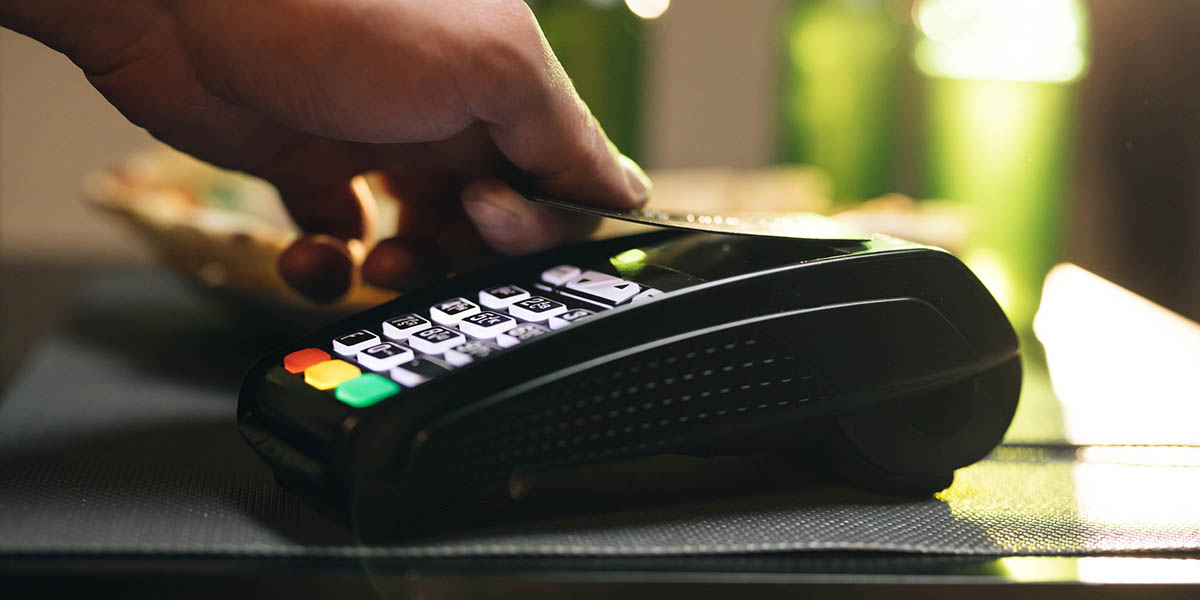 Credit card machine for money transaction. Close up of male hold in hand wireless modern bank payment terminal to process acquire credit card payments black card. Credit card through pos terminal