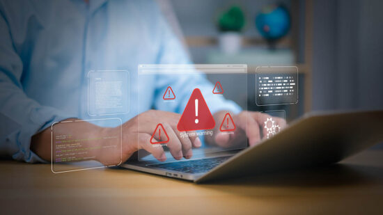 Cybersecurity, virus protection, Hand on laptop with holographic System warning and red alert icons. Symbolizes cyber threats, data security breaches, and IT system errors. digital risk management now