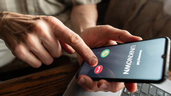Senior man refuses to answer to a call from unknown number. Scam and fraud prevention with smartphone concept.